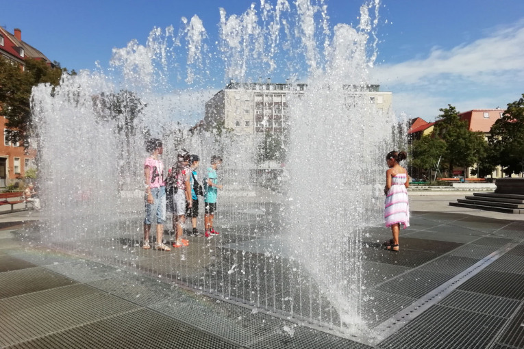 Kinder stehen zwischen den Wasserfontänen des Jeppe-Hein-Brunnens