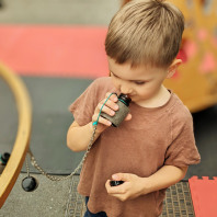 Ein kleiner Junge riecht auf dem Mobilen Erfahrungsfeld der Sinne an einem Gefäß.