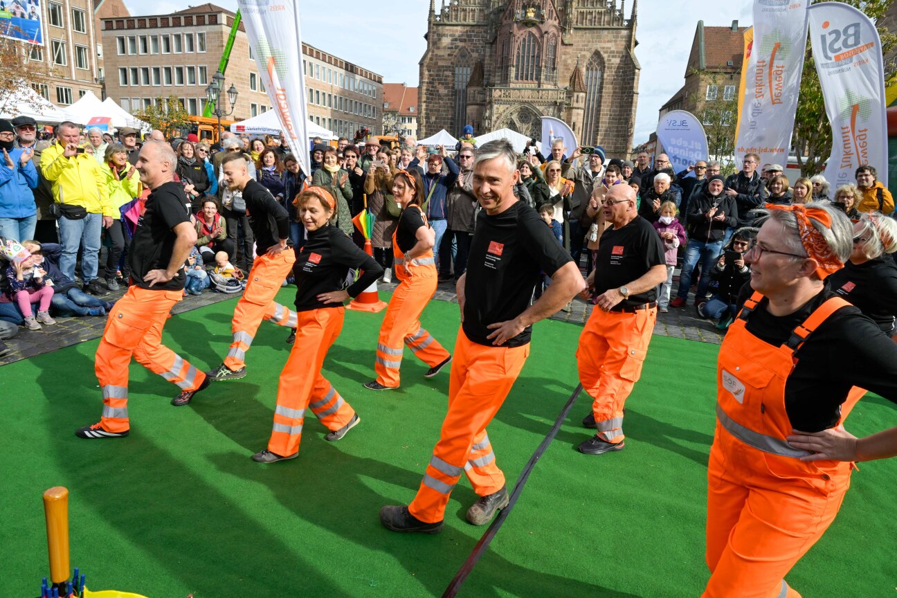 Bild © Anestis Aslanidis Sör-Ballett: Mitarbeitende von Sör, in orange gekleidet, führen auf dem Hauptmarkt einen Tanz auf., Bild © Anestis Aslanidis