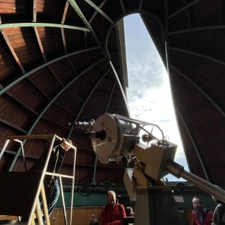 ( Bild: Sabine Hieronymus ) In der Kuppel der Starnwarte. Die hölzerne Kuppel ist geöffnet und gibt den Blick auf den Himmel frei. Im Vordergrund steht ein großes Teleskop.