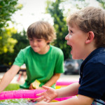 Zwei Jungs spielen im Freien mit Wasser.