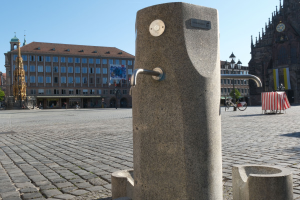 Blick auf den Trinkwasserbrunnen auf dem Hauptmarkt. Im Hintergrund sind der Hauptmarkt und die Frauenkirche zu sehen.
