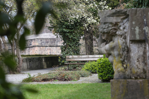 Ein Blick in den Bürgermeistergarten mit Skulpturen, Grün und einer Parkbank