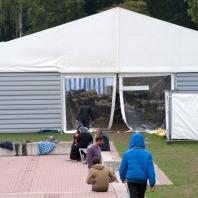 Geflüchtete Menaschen vor einem Zelt im Stadionbad