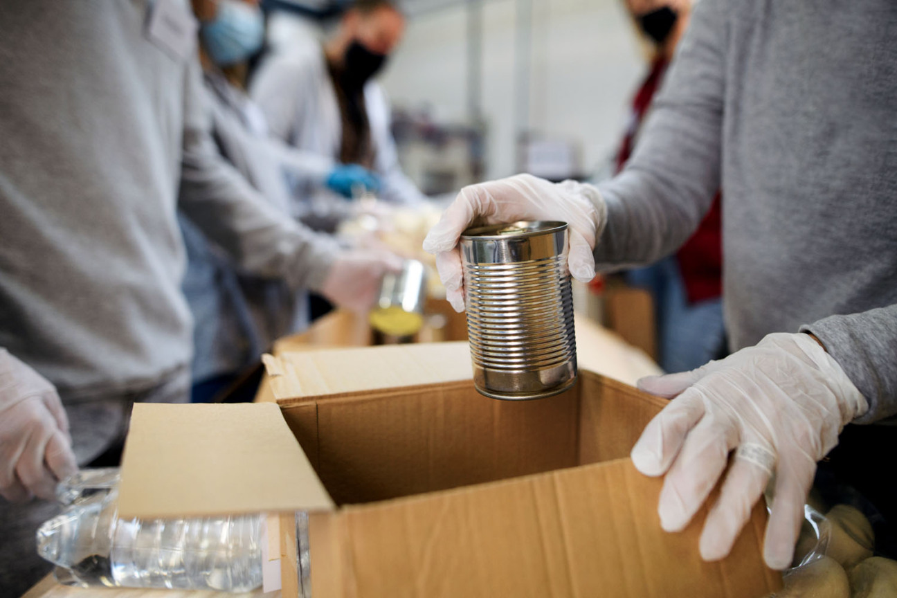 Bild © Halfpoint - Adobe Stock Eine Gruppe freiwilliger Helfer packt Carepakete für Flüchtlinge aus der Ukraine., Bild © Halfpoint - Adobe Stock