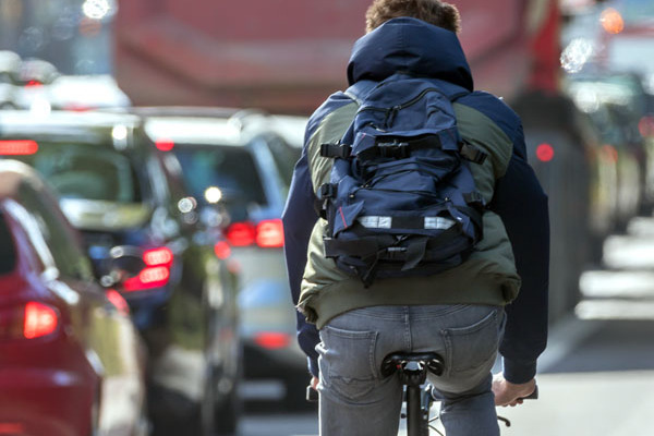 Radfahrer fährt an einem Stau in de Stadt vorbei.