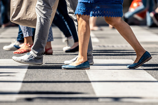Fußgänger überqueren einen Zebrastreifen.