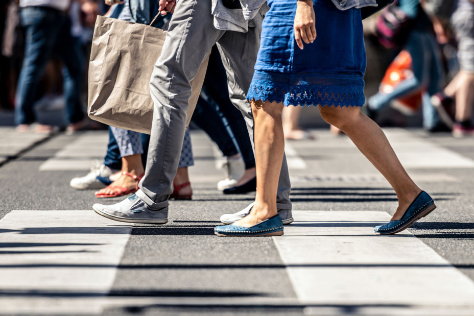 Fußgänger überqueren einen Zebrastreifen.