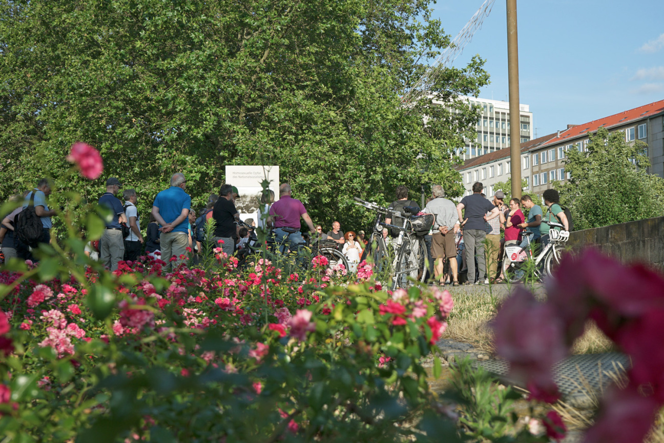 Bild © Leopold Werner / Stadt Nürnberg Blumen im Vordergrund; im Hintergrund haben sich Menschen bei einer Mobilen Bürgerversammlung versammelt., Bild © Leopold Werner / Stadt Nürnberg