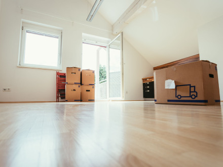 Das Bild zeigt eine leere Wohnung mit Umzugs·kartons.